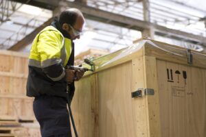 operario con un embalaje de madera que cumple la normativa