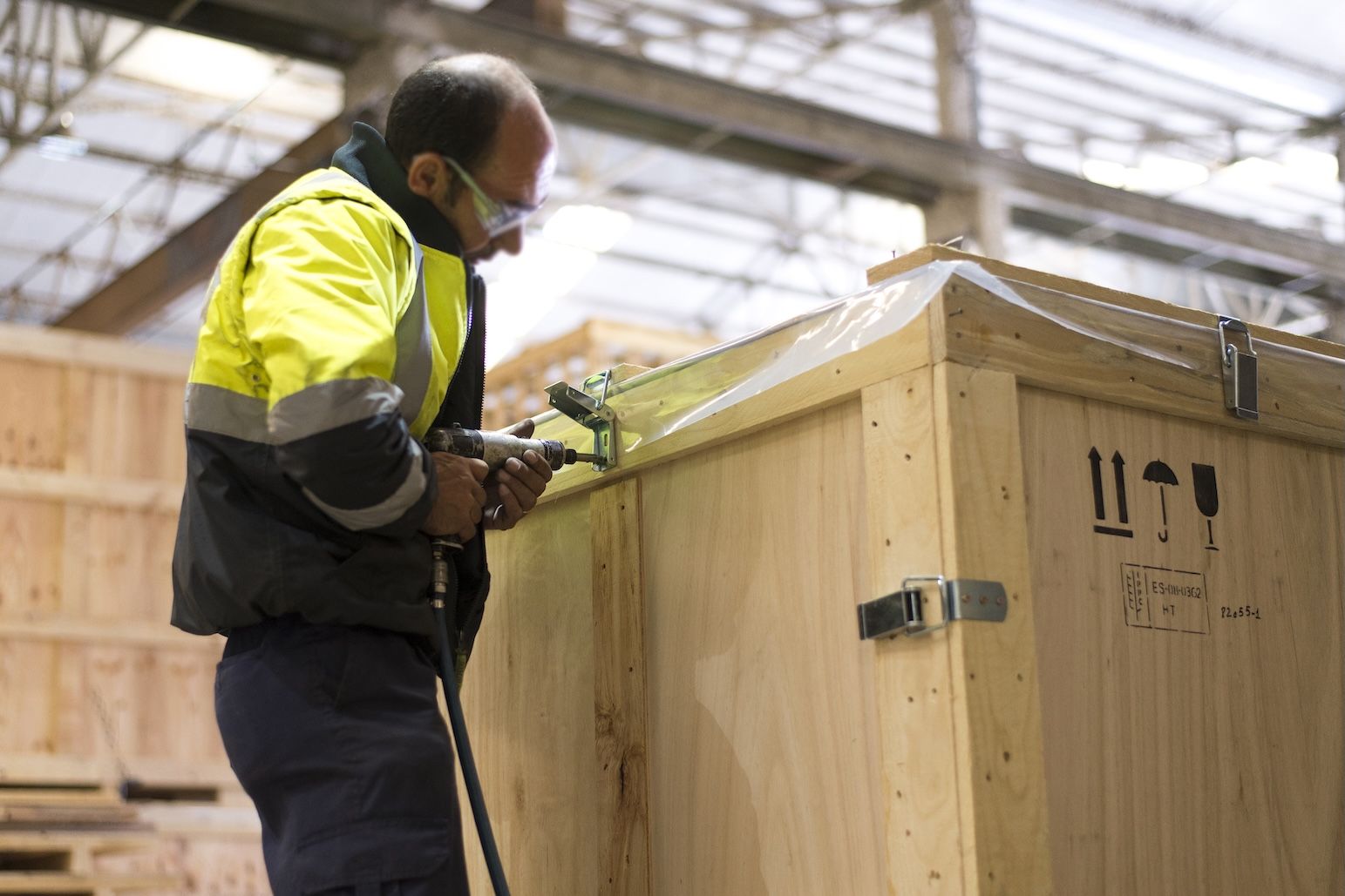 operario con un embalaje de madera que cumple la normativa