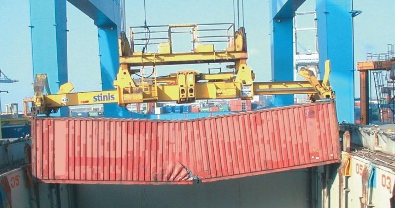 Grúa sujetando contenedor con suelo partido