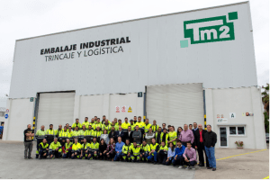 el equipo de Tm2 posa frente a las instalaciones de la empresa, en el Puerto de Barcelona